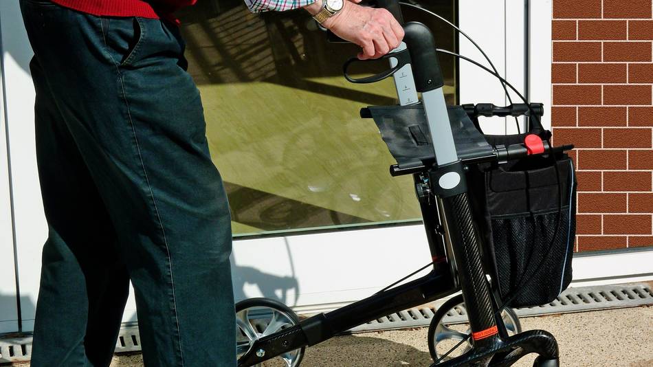 Aktiv und fit mit dem Rollator Ein älterer Herr geht mit einem Rollator.
