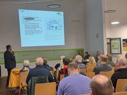 Menschen sitzen in Reihen und schauen nach vorne zur Präsentation