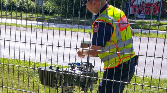 Ein Mitarbeiter des Kommunalen Ordnungsdienstes der Stadt Neumünster installiert das Radar-Messgerät.