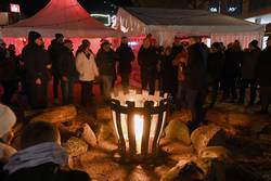 Der Feuerkorb im Weihnachtsdorf zieht durch seine Wärme und seinen Feuerschein die Menschen an.