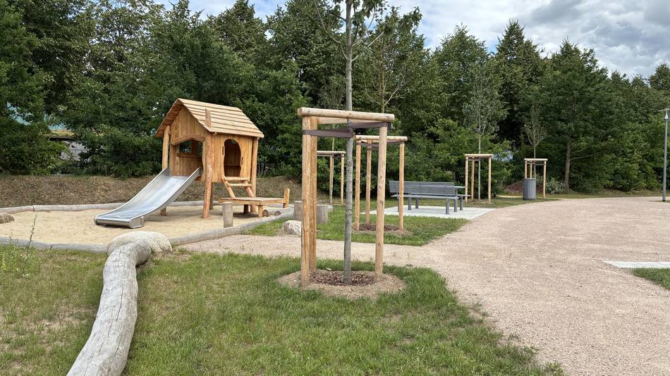 Für Kleinkinder entstand der hier abgebildete Sandspielbereich mit Holzhaus und Rutsche.