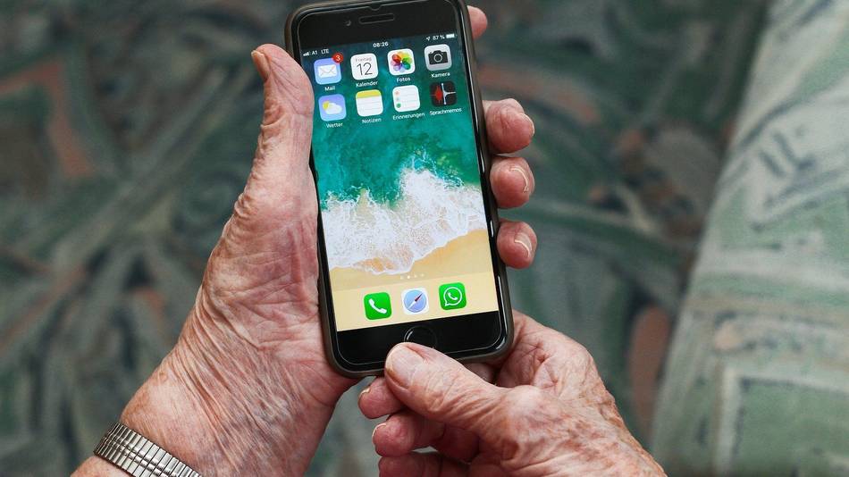 Digitallotsen Symbolbild: zwei ältere Hände halten ein Smartphone