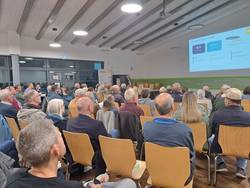 Menschen sitzen in Reihen und schauen nach vorne zur Präsentation
