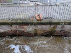 Viel Wasser fließt unter einer Brücke durch
