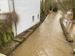 viel Wasser im Fluss neben einem Haus