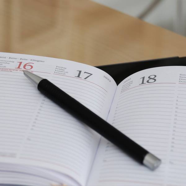 aufgeklappter Kalender mit einem Stift