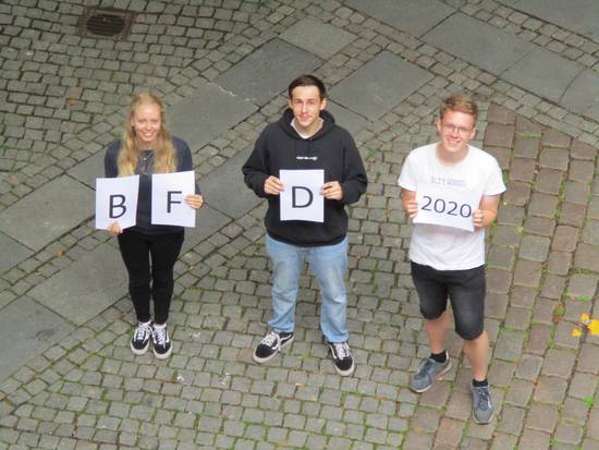 Drei junge Menschen mit BFD-Buchstaben